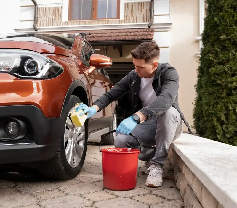 Lavage auto à domicile Hérouvillette : professionnel intervenant sur un véhicule